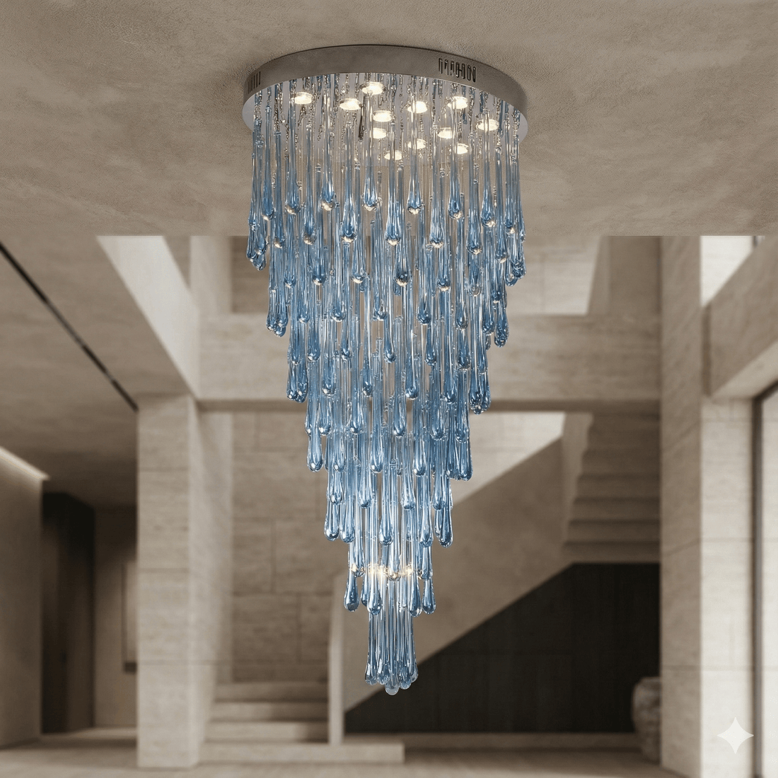 Large blue glass teardrop chandelier installed as a flush mount in a luxury entryway, dramatic cascading glass design with round canopy